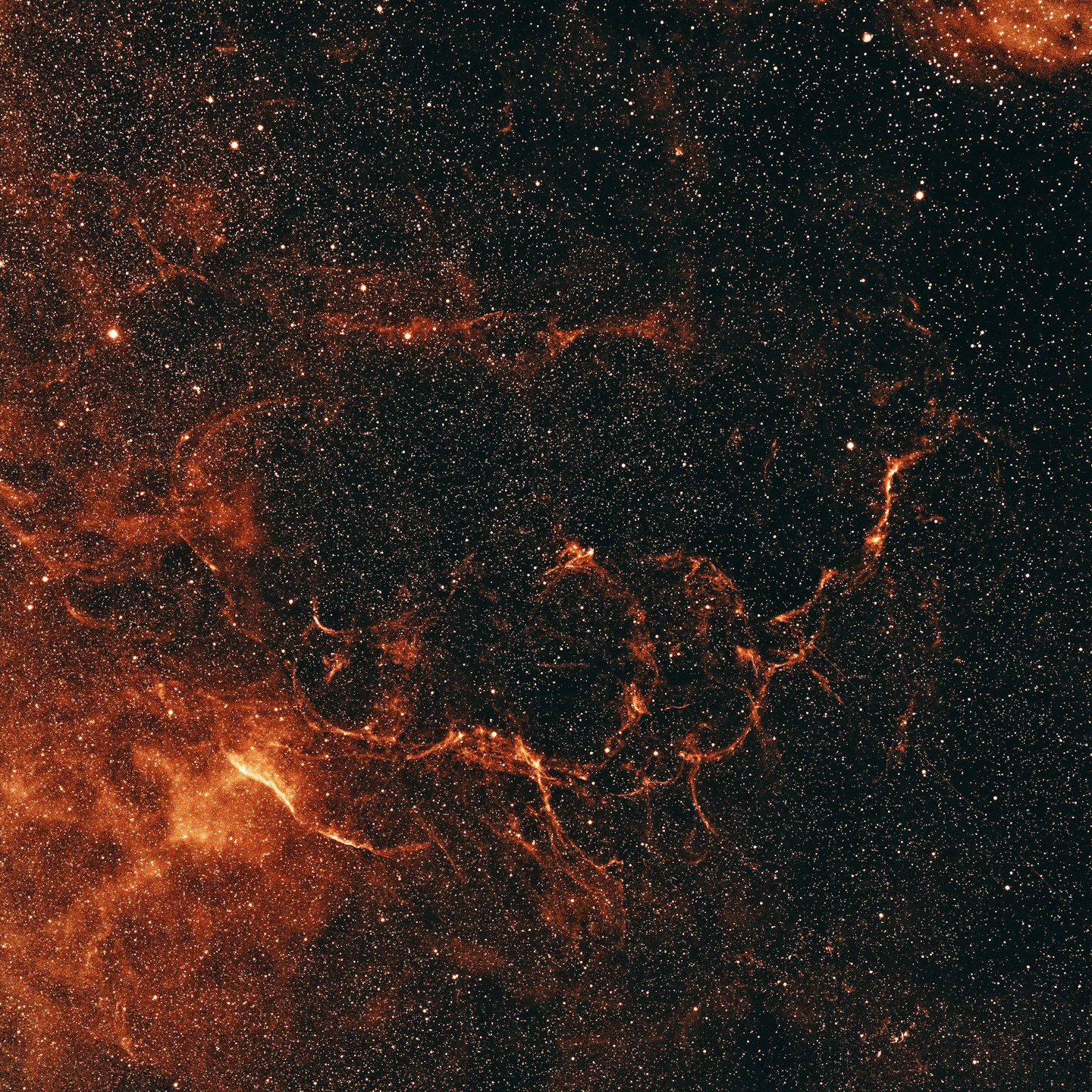 A vibrant orange and red nebula glows in deep space.